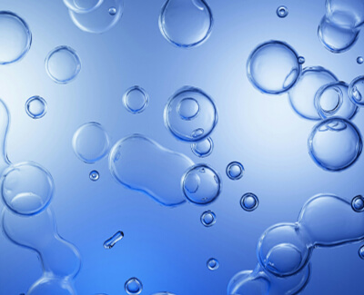Clear bubbles of various sizes floating against a blue gradient background.