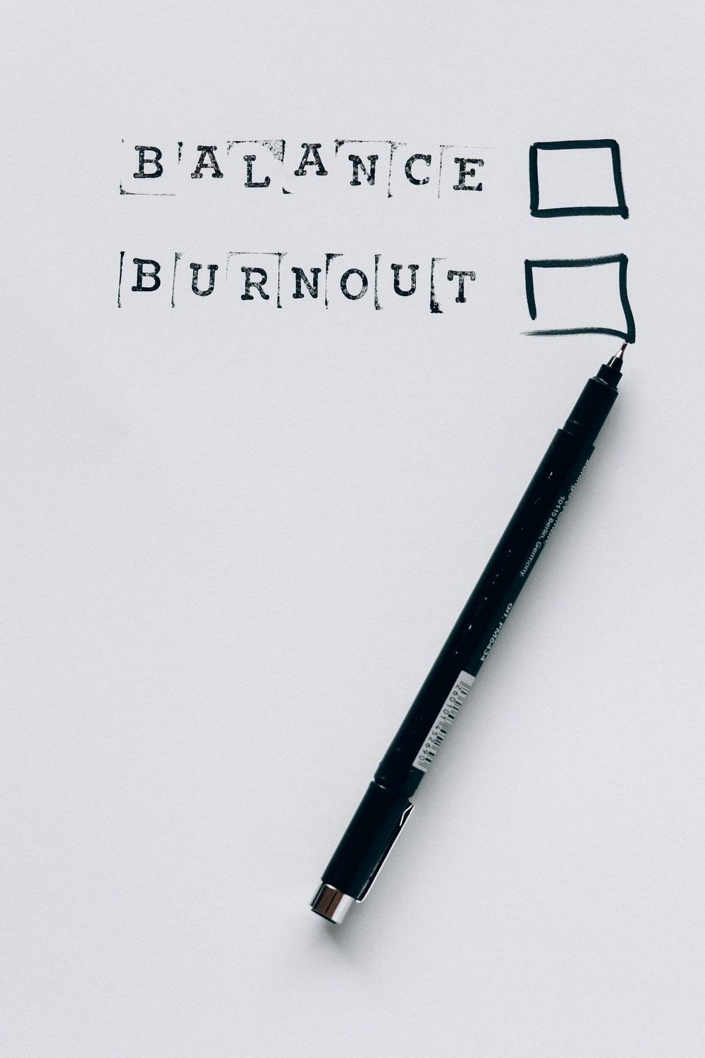 A marker next to two checkboxes labeled "BALANCE" and "BURNOUT" on a white surface, with neither box checked.